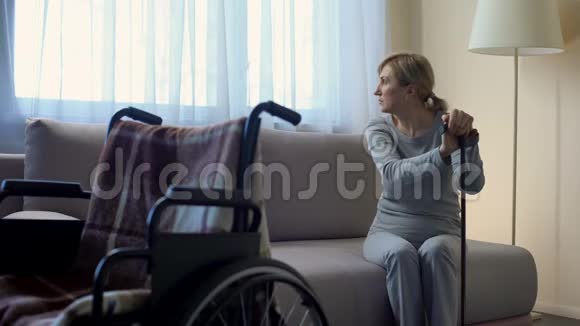 悲伤的退休女士在医院等待丈夫看着轮椅康复视频的预览图
