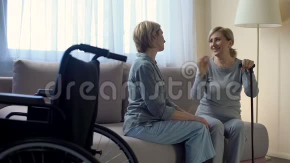 残疾母亲坐在沙发上与女儿交谈家庭支持视频的预览图