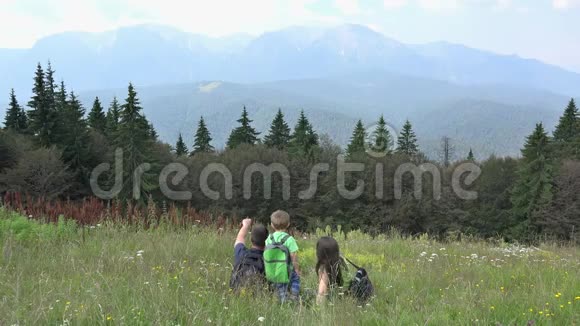 一家人背着背包躺在草地上欣赏大自然视频的预览图