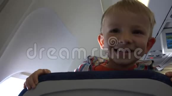 坐飞机坐在椅子后面玩捉迷藏的快乐儿童脸视频的预览图