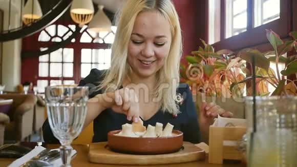 格鲁吉亚菜金发碧眼的人在奶油酱里吃Khinkali慢动作视频的预览图