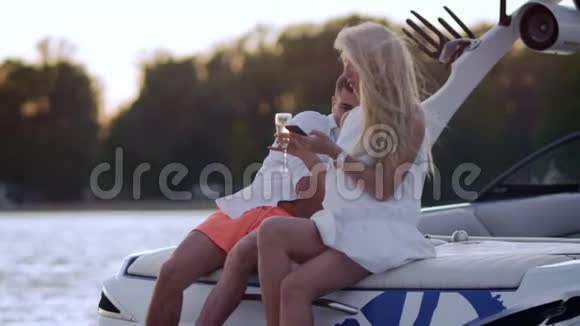 在湖上游艇上的豪华度假日落时分年轻人在游艇上划船视频的预览图