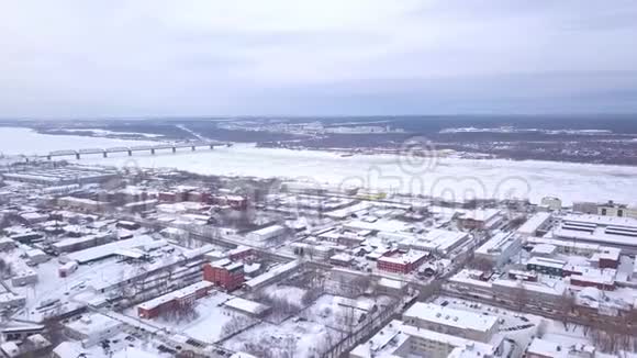 鸟瞰冰冻河流冬季景观削减冬季河流结冰的城市俯瞰图视频的预览图