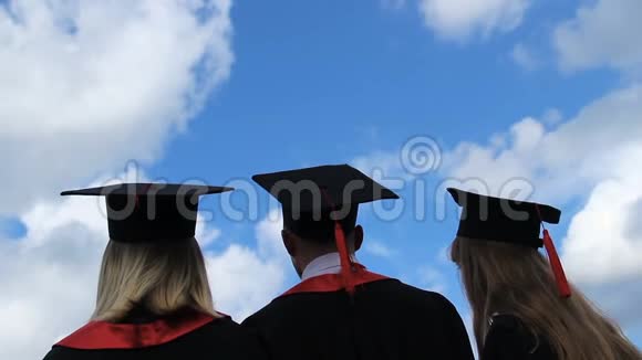 毕业生的美好未来三个学生高举学术帽子视频的预览图