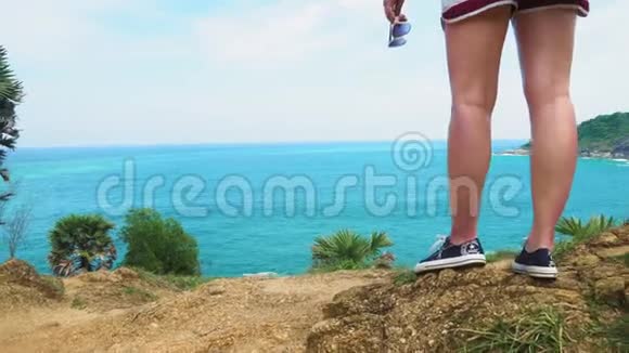 一个带背包的旅游女孩的脚与岛屿的海景视频的预览图
