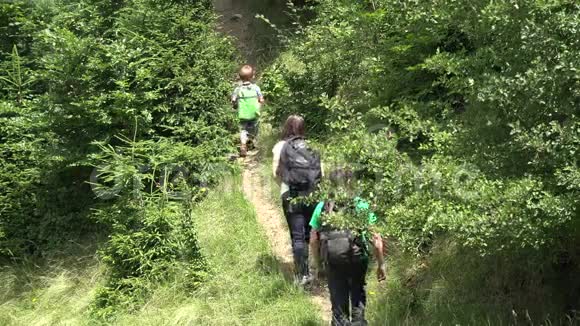 小孩子和他的父母在山上徒步旅行一家人在山上散步视频的预览图