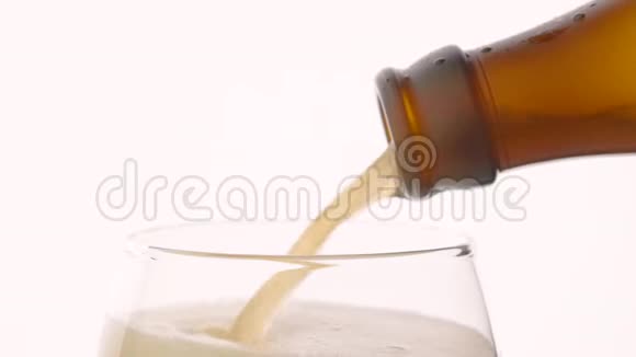 慢速啤酒从白色背景的棕色瓶子中倒入玻璃视频的预览图