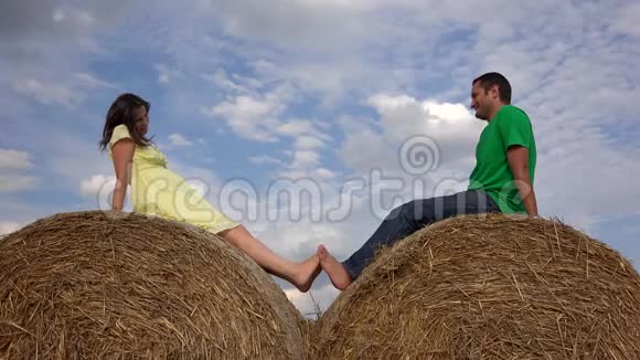 一对情侣在干草堆上裸着脚玩着奥尔斯的天空视频的预览图