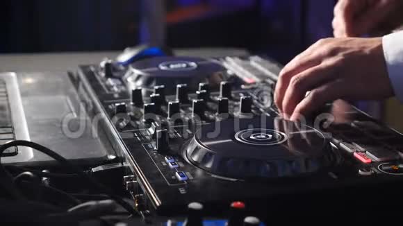 控制台后面的DJ在舞台上混合轨道在大气舞蹈派对闪光灯和闪光灯关闭DJ手视频的预览图