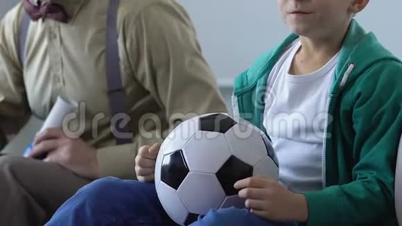 孩子和爷爷一起看足球赛支持最喜欢的球队视频的预览图