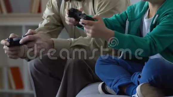 快乐的老人和孙子在家玩电子游戏花时间在一起视频的预览图