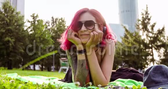 红头发的女孩躺着放松的公园草地视频的预览图