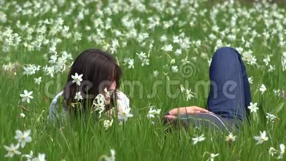 一对在水仙花草地上玩耍的情侣温柔的抚摸视频的预览图