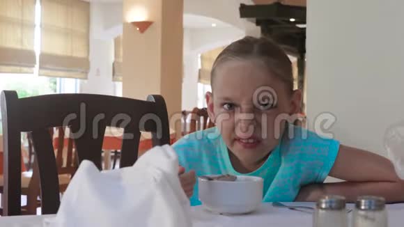 在餐馆吃早餐时做鬼脸的女孩视频的预览图