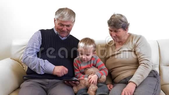 不同的世代祖父母和孙子玩平板电脑视频的预览图