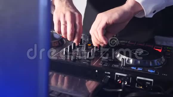 控制台后面的DJ在舞台上混合轨道在大气舞蹈派对闪光灯和闪光灯关闭DJ手视频的预览图