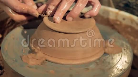 一个陶工在一个新碗的脚上雕刻视频的预览图