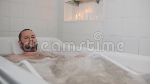按摩温泉里的那个人在热水浴缸里一个正在洗澡的男人正在进行娱乐水疗按摩视频的预览图