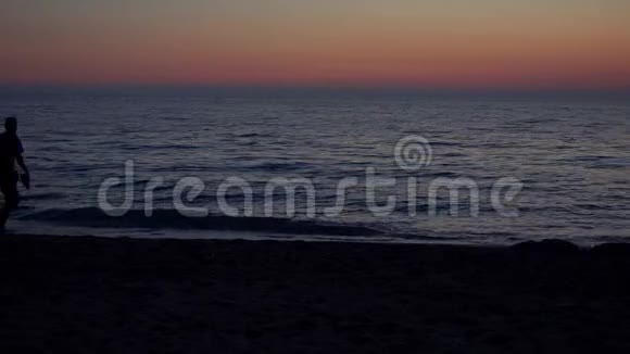 日落时分一对情侣在海滨漫步浪漫漫步视频的预览图