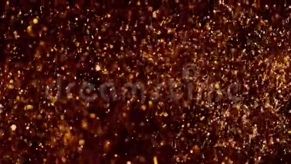 金色的光芒闪耀在黑色上美丽的抽象纹理铜颗粒在水中混沌运动黄金黄金视频的预览图