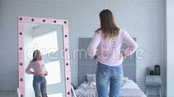 美丽的女人照镜子检查她的体形视频的预览图