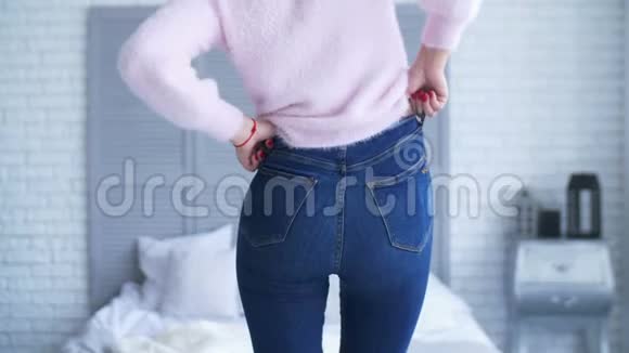 卧室里穿紧身牛仔裤的超重女士视频的预览图