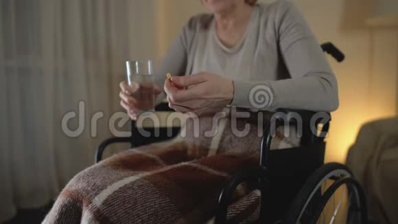 坐在轮椅上的悲伤老人吃药恢复期抑郁视频的预览图