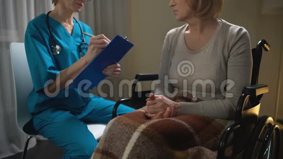 医生随叫随到与轮椅上的患病妇女交谈并做记录诊断视频的预览图