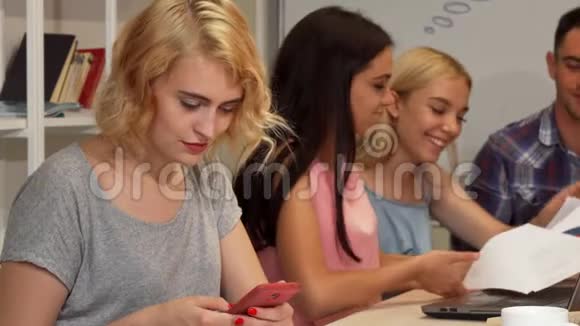 年轻女商人开会时使用智能手机视频的预览图