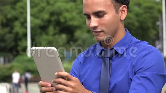 年轻的西班牙裔商人用平板电脑发短信视频的预览图