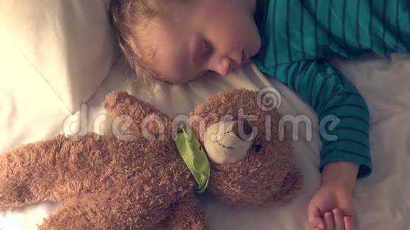 小男孩和泰迪熊玩具倒着睡视频的预览图