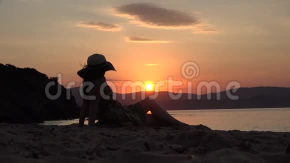 坐在海边欣赏海上彩色日落的美女视频的预览图