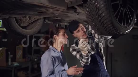 英俊的年轻汽车技师向一位年轻的女性客户解释了修理过程视频的预览图