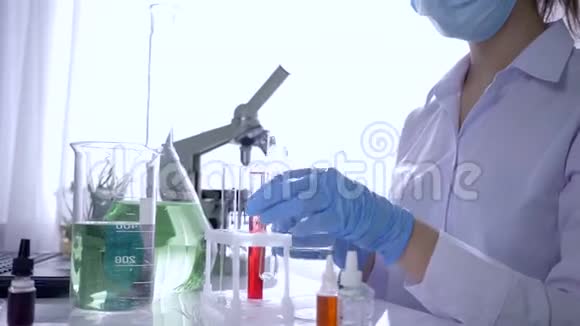 女化学家手里拿着试管和注射器正在现代实验室试验试剂视频的预览图