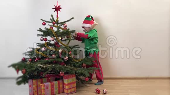 有趣的小精灵在圣诞树上布置装饰品快乐的孩子在等待圣诞节视频的预览图