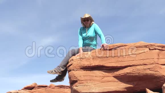 白种人女游客坐在大峡谷的石岩上视频的预览图