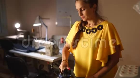 女裁缝在裁缝车间用专业的铁蒸制羊毛服装女人的手握着铁视频的预览图