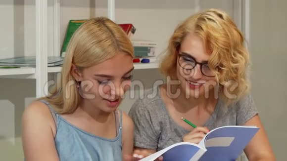 年轻女生在大学礼堂读课本视频的预览图