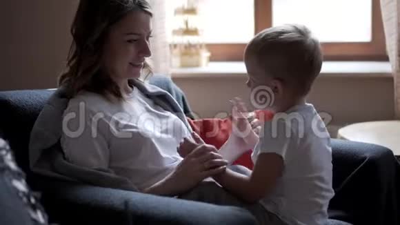 小男孩和怀孕的妈妈玩视频的预览图