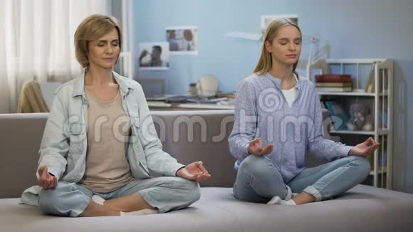 母女俩在家打坐练瑜伽互相了解视频的预览图