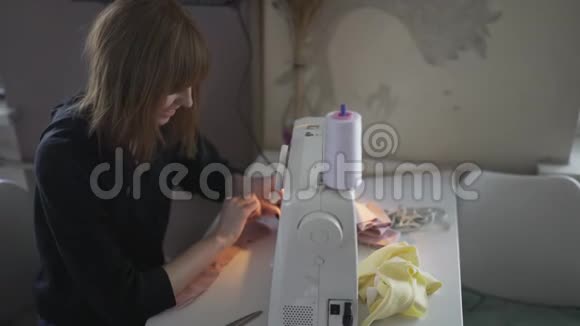 女时装设计师裁缝裁缝裁缝晚上在家里做缝纫机红发女工视频的预览图