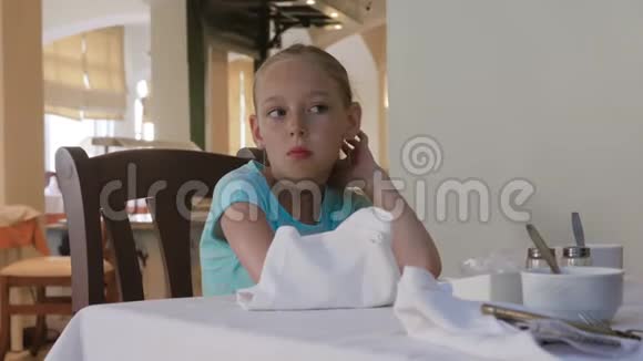 可爱的女孩在餐馆吃早餐时嚼点东西视频的预览图