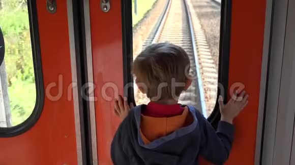 小孩子望着火车窗外做梦走近目的地视频的预览图