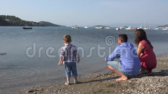 快乐的孩子和父母在海滨年轻的家庭一起玩微笑视频的预览图