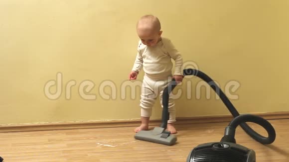 可爱勤奋的男婴用吸尘器打扫房子视频的预览图
