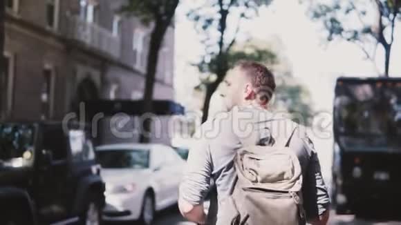 镜头跟随年轻放松的男性自由职业者背包在布鲁克林的林荫街道慢动作视频的预览图