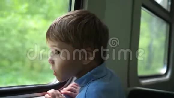 这个男孩坐火车旅行望着窗外看着窗外移动的物体旅行与视频的预览图