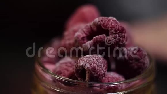 树莓被放置在玻璃罐中的粉红色块表面作为装饰视频的预览图