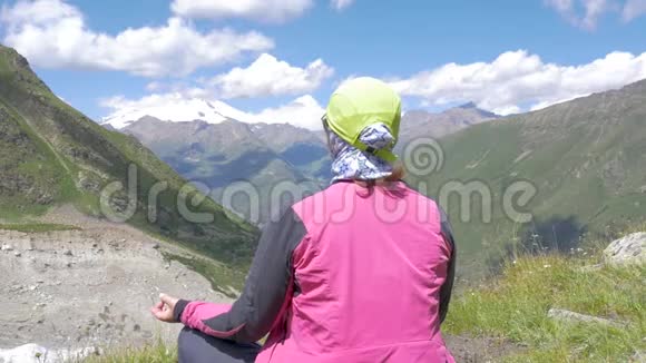一个女人坐在高山上沉思埃尔布鲁斯风景不错视频的预览图