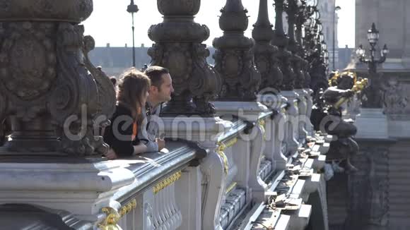 迷人的年轻男女从桥上欣赏城市美景浪漫之旅巴黎亚历山大桥视频的预览图